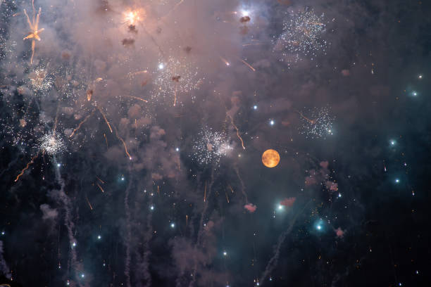 Colorful fireworks in the night sky with full moon.