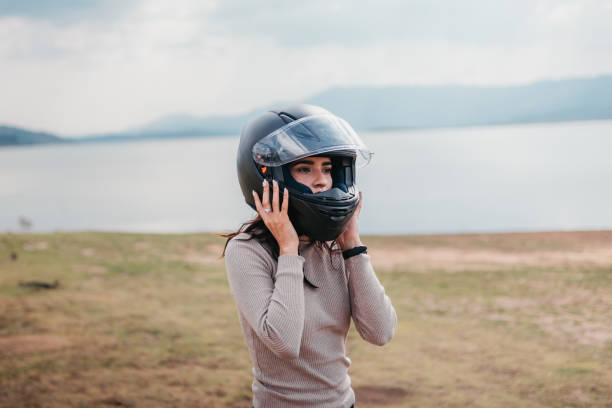 istock A female motorcyclist fastens her helmet 2071385635