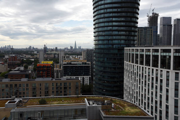 London Cityscape with the Canary Wharf business diestrict. The image shows several tall business buildings with cloudy sky, captured during summer season.