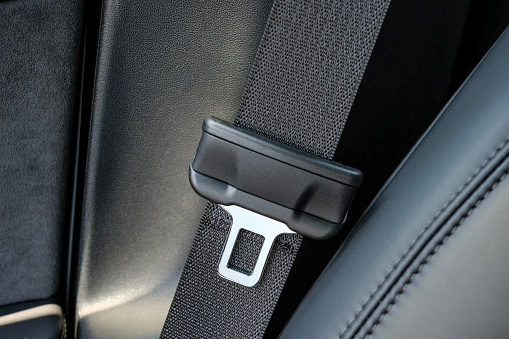 A close up photograph of a modern car seatbelt buckle.