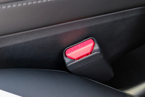 A close up photograph of a modern car seatbelt lock.