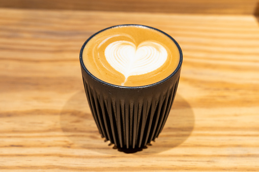 A Close-Up View of a Latte with a Beautiful Heart Shaped Milk Art on Top, Served in a Dark Mug