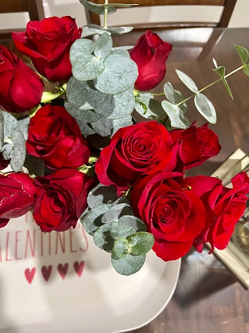 A bouquet of roses in a vase on a table.