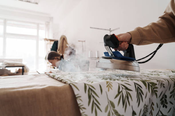 istock Female tailor ironing fabric in a bright sewing workshop 2071487945
