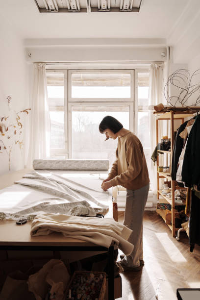 istock Craftswoman tailoring fabric in her sunlit sewing studio 2071488206