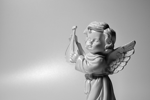 Death concept. Little beautiful angel crying as symbol of pain, fear and end of human life. Fragment of an ancient statue. Copy space for design.