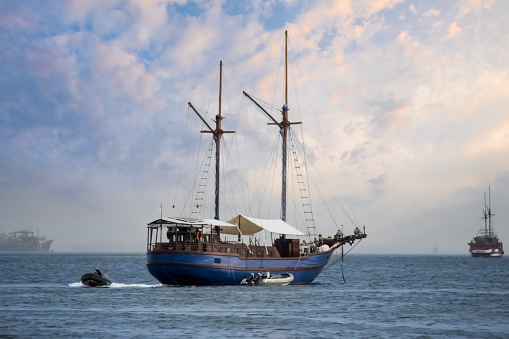 Behold the serenity of an Indonesian traditional boat gently moored on the tranquil surface of a calm sea.