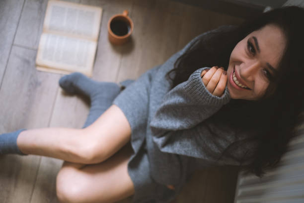 istock Young Woman Enjoying Her Coffee And Book 2071547112
