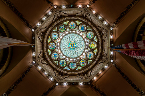 In Memorial Hall, the elaborate stained-glass skylight features the seal of the Commonwealth of Massachusetts at center, surrounded by the state seals of the other twelve original states.