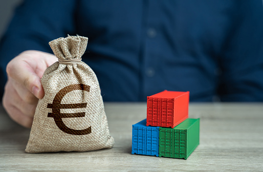 Shipping containers and euro money bag. Profit from sales of goods. Economic growth, increased production and development of transport infrastructure. Make a trade deal. Import and export.