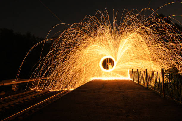 Kyiv, Ukraine - July 07 2013: spinning the steel wool on railway station platform. Sparks flying out in all directions due to centrifugal force.