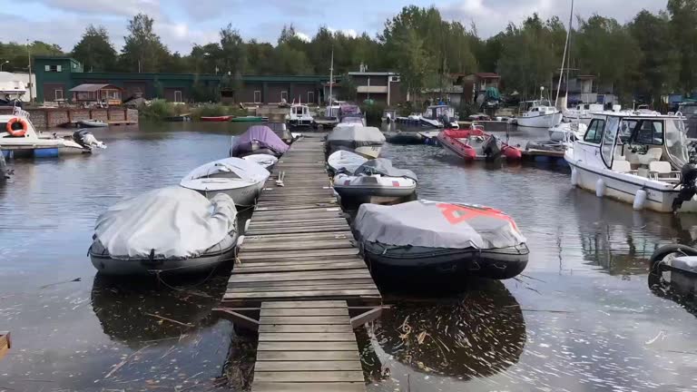 boats moored to booms and swinging on the waves