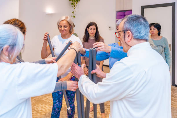 istock Qi gong class members picking up a tube to exercise 2071626116