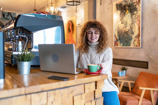 beautiful woman working on laptop at coffee shop - caffeine caucasian satisfaction small business - fotografias e filmes do acervo