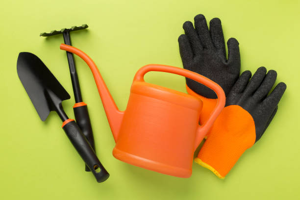 istock Orange gardening tools on color background, top view 2071763385