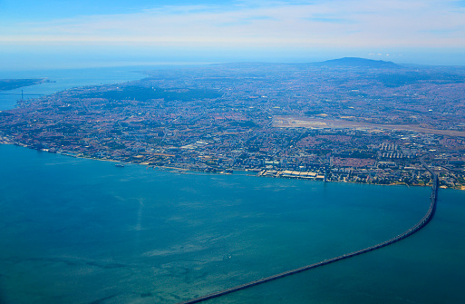 Lisbon, Portugal: aerial view of the Mar da Palha (Sea of Straw) inland sea in the Tagus River estuary and the city of Lisbon from the east. Above the bridge the Lisbon International Airport can be seen. The river mouth on the Atlantic, near Almada can be seen on the top right. Sintra mountains can be seen in the horizon.