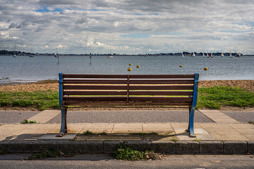 Poole, Dorset, England, UK - September 28, 2022: A bench overlooking Parkstone Bay