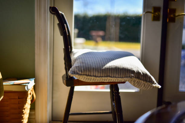 Old vintage wooden chair with a pillow on top,  placed in from of French door
