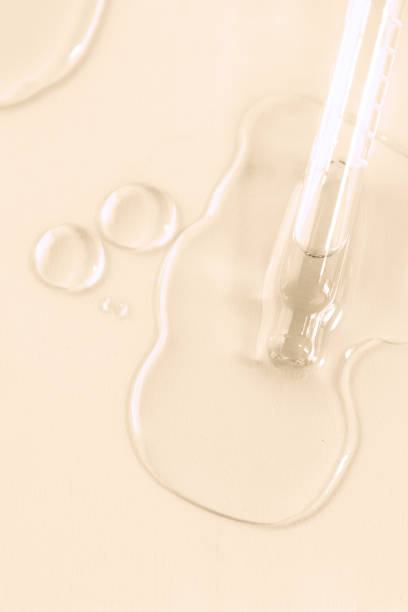 istock Dropper pipette with trasparent drops on smear with bubles on beige background. Abstract serum, oil , acid cosmetic product 2071934569