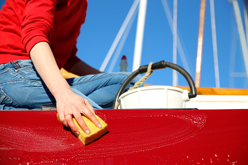 Close-up of a young woman cleaning her boat in a marina, Holland