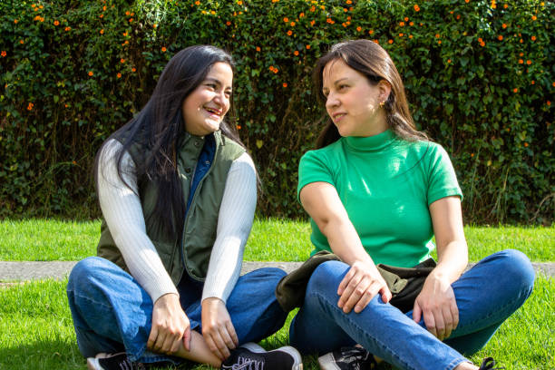 istock Two beautiful young women having fun in a public park 2072033344