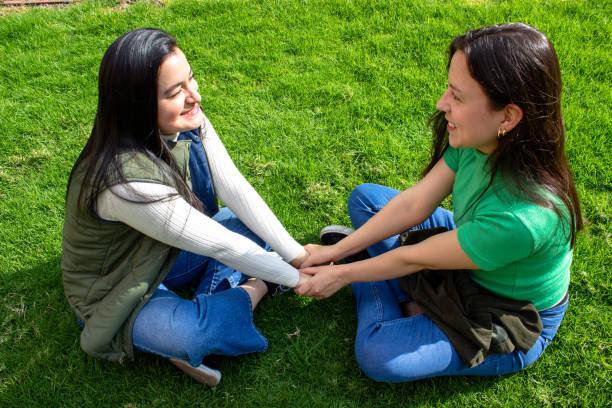 happiness lesbian couple touching the feet at the park