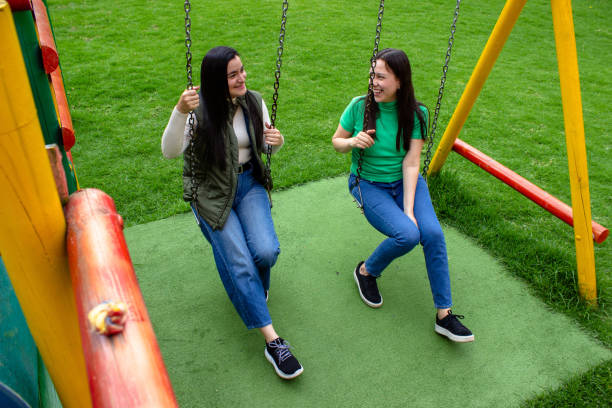 istock Two beautiful young women having fun in a public park 2072037088