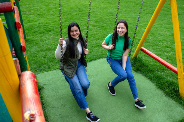istock Two beautiful young women having fun in a public park 2072037606