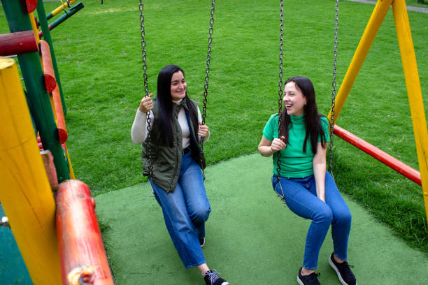 istock Two beautiful young women having fun in a public park 2072037612