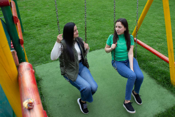 istock Two beautiful young women having fun in a public park 2072037615