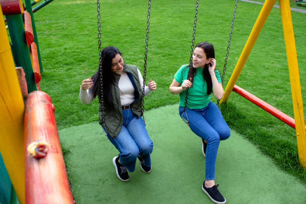 istock Two beautiful young women having fun in a public park 2072037616