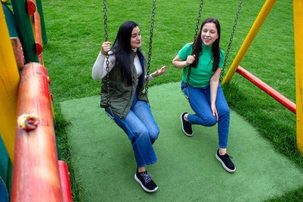 istock Two beautiful young women having fun in a public park 2072037620