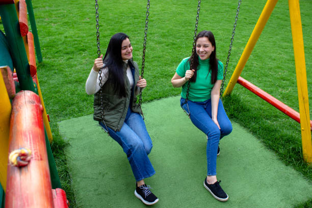 istock Two beautiful young women having fun in a public park 2072038123