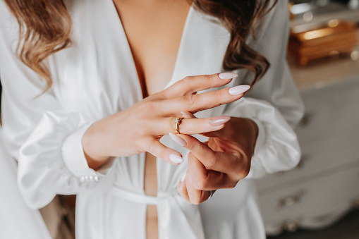 Cropped photo of bride putting wedding ring on her finger