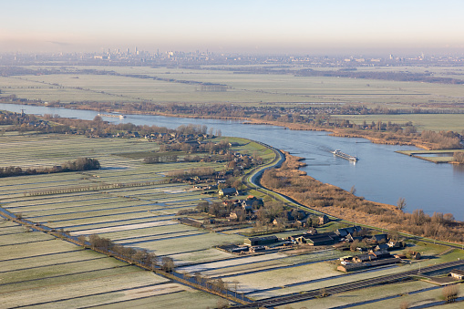 Aerial view flying above Dutch river Lek near Rotterdam with view at village Schoonhoven