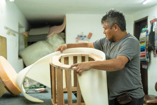 Latin man making furniture in carpentry, in a small carpentry shop