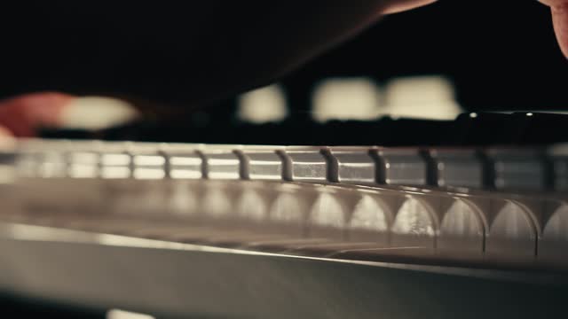 Young woman pianist playing classical music on a grand piano close-up. Classic music concert or repetition