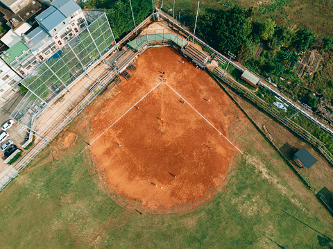 View from a drone, the location of the baseball field and the hardworking baseball team practicing in it is captured.
