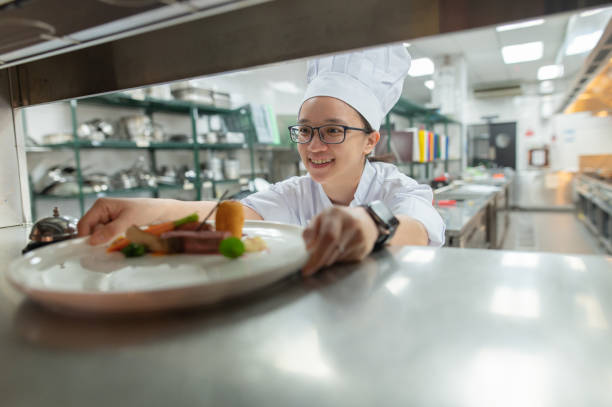 asian female cooking apprentice put the food to counter - hygiene food chef trainee zdjęcia i obrazy z banku zdjęć