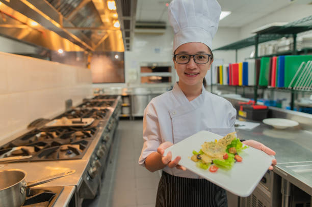 istock Asian female kitchen apprentice decorate the food 2072341625