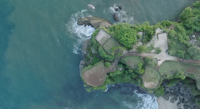 Top down drone shot over tropical Balangan Beach peninsula in Uluwatu Bali Indonesia with crashing waves and turquoise water