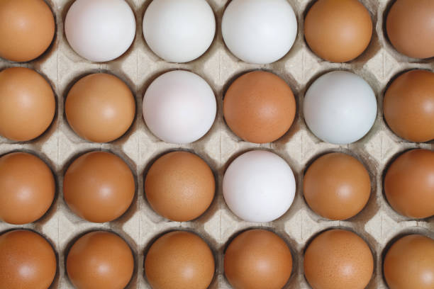 istock Chicken eggs in a cardboard box ready to cook on a yellow background 2072450047