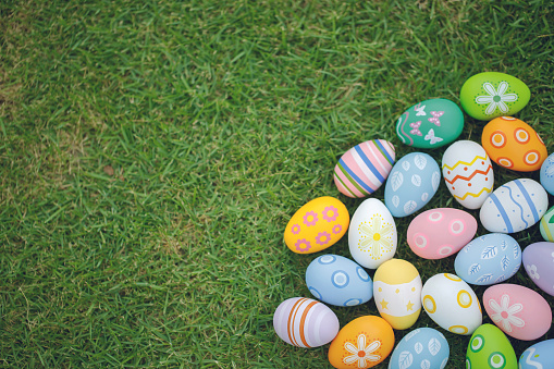 Collection of colorful easter eggs on green grass to celebrate Easter or spring.