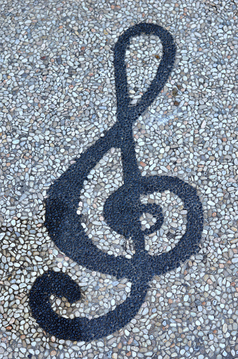 Treble clef on an old music score. Treble clef is made of Medium-density fibreboard and is on a music score from Bach's Art of Fugue published in Leipzig c. 1750 and is in public domain.  Ideal image for musical themes. It is an exclusive image and it can only be found in iStockphoto.