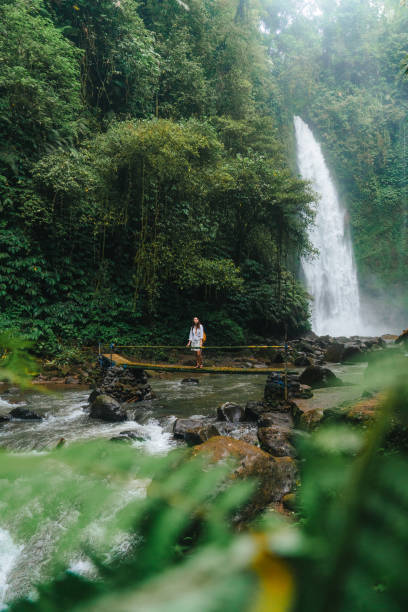 istock Woman standing near the refreshing waterfall on Bali 2072493170