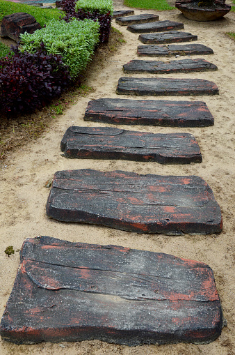 a curvaceous foothpath made of concrete blocks on the garden