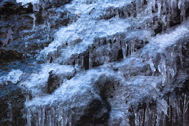 Cascade of ice on a wet cliff in a frozen waterfall, in winter at Blackledge Falls Park in Glastonbury, Connecticut.