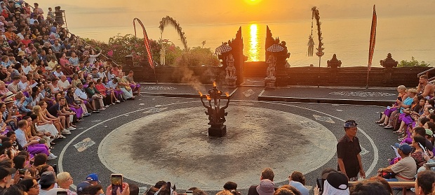 Uluwatu, Bali - September 30, 2023: Open air performance arena of Kecak dance with people sitting surrounding the place and fire torch in the center