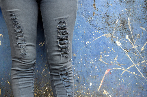 black faded jeans on concrete wall