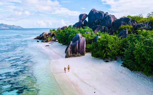 istock Anse Source d'Argent beach, La Digue Island, Seyshelles, Drone aerial view of La Digue Seychelles bird eye view, couple men and woman walking at the beach during sunset at a luxury vacation 2072667210